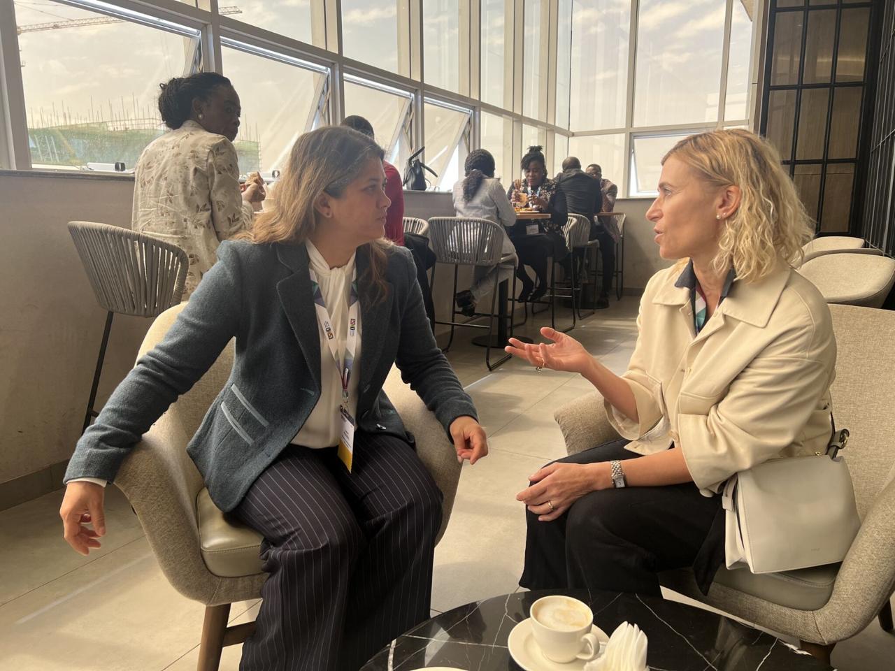 Two participants in conversation during a coffee break.