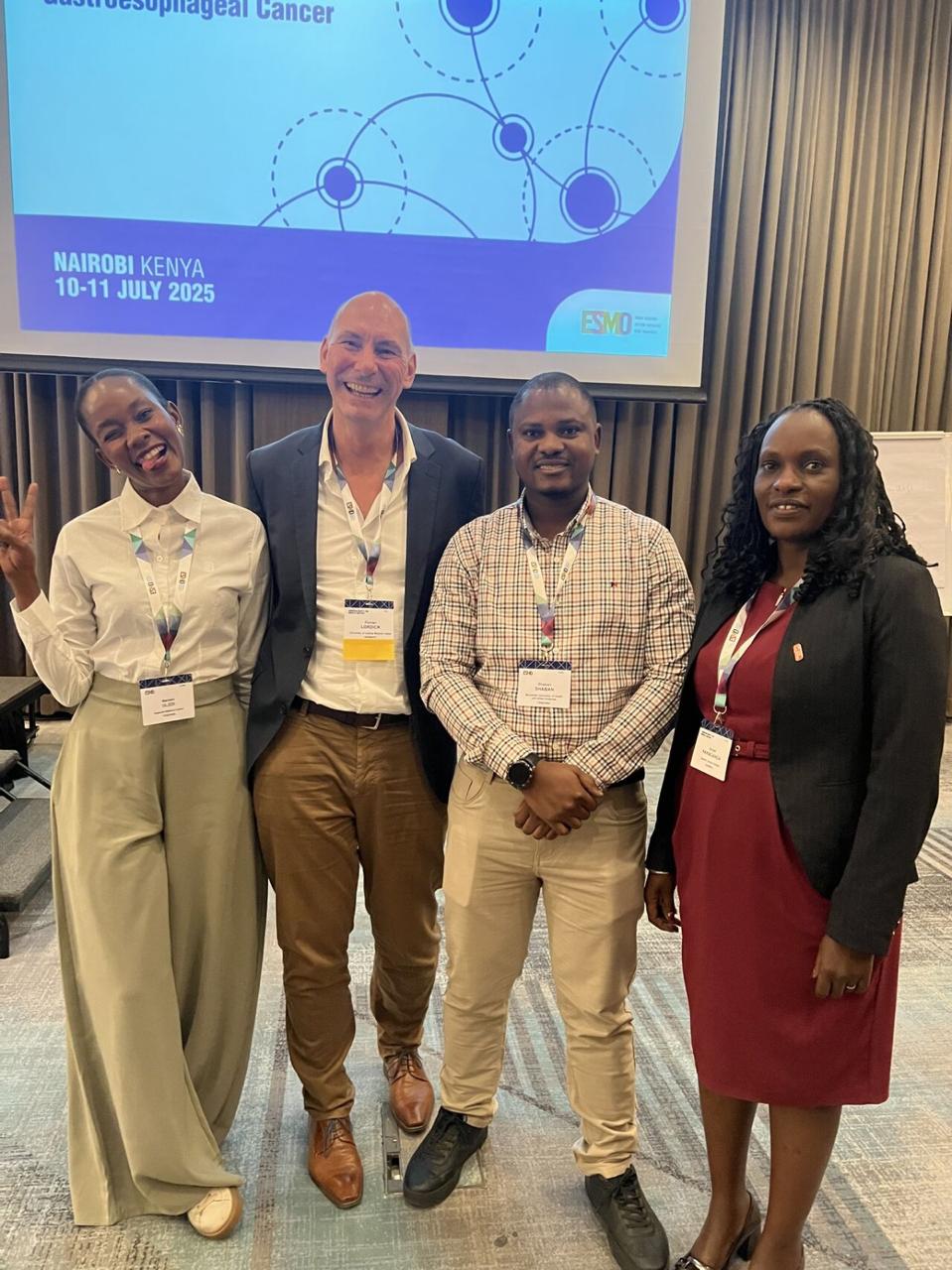 AFROC team members standing together in front of the conference screen.