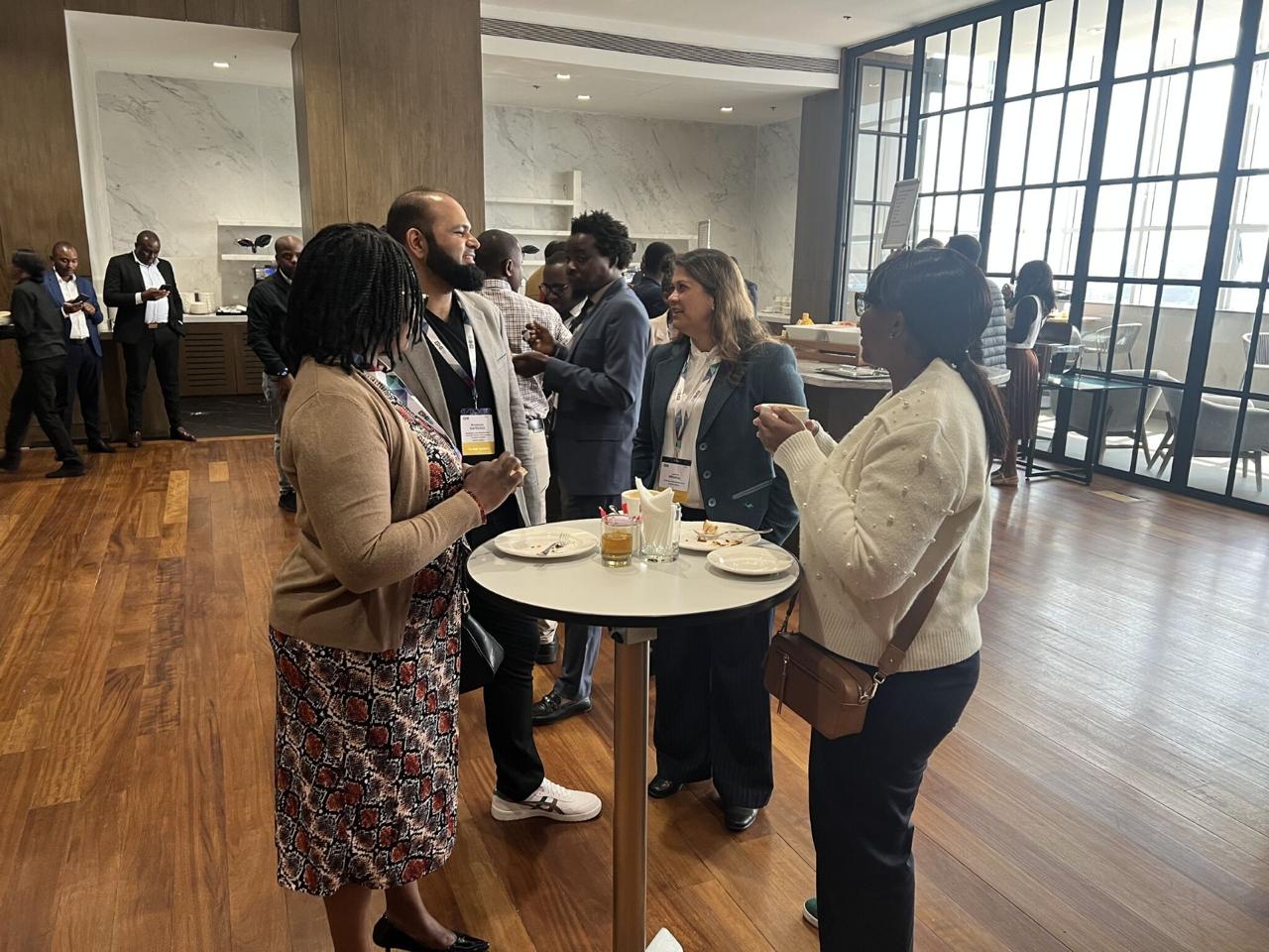 Participants networking around a high table during a break.