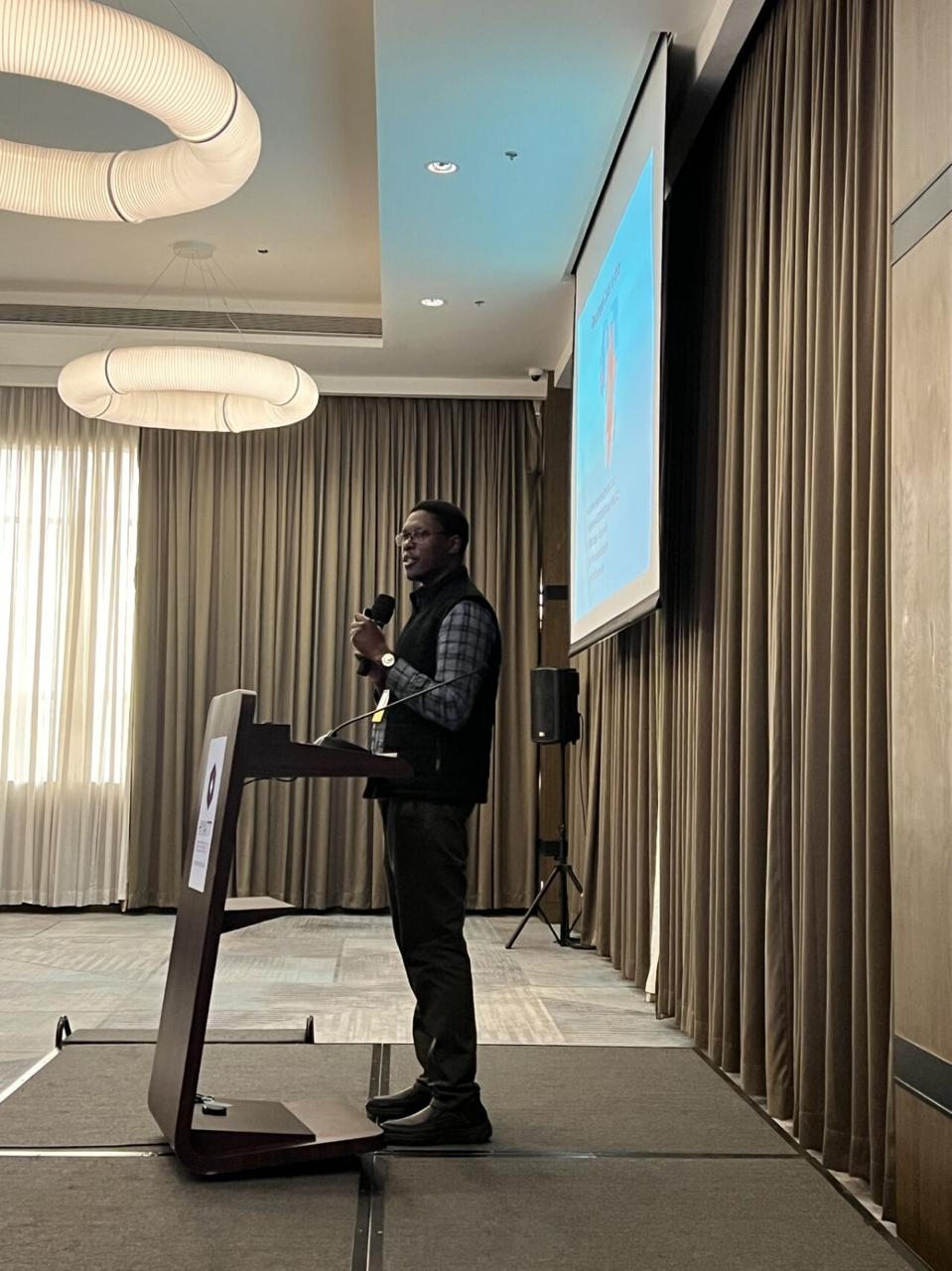AFROC speaker standing at a podium during a presentation.