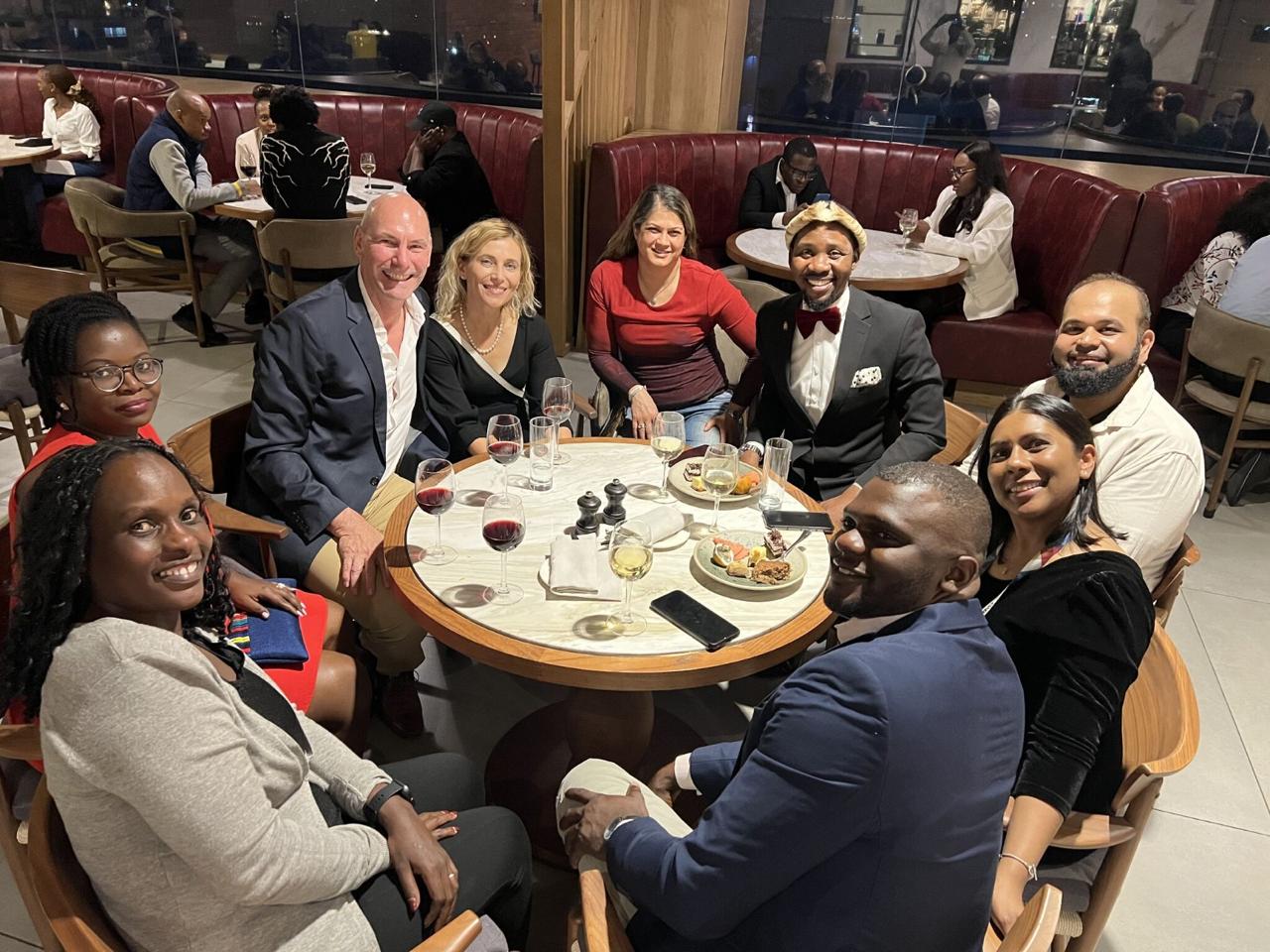 AFROC team and collaborators gathered around a dinner table.